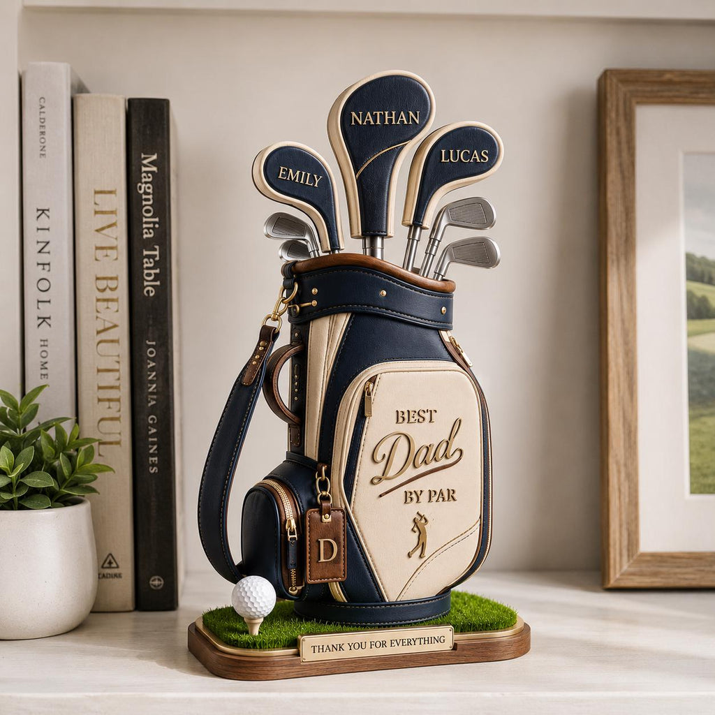 May include: A golf bag sculpture with the words "Best Dad by Par". The bag is navy blue and cream-colored, with golf clubs and the names "Nathan", "Emily", and "Lucas" on the club heads. A golf ball sits on a tee.