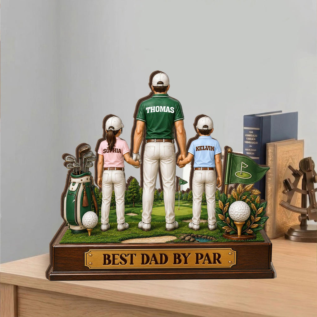 May include: A wooden golf-themed decorative piece featuring a father and two children holding hands on a golf course. The piece includes a golf bag, golf ball, and the text "BEST DAD BY PAR".