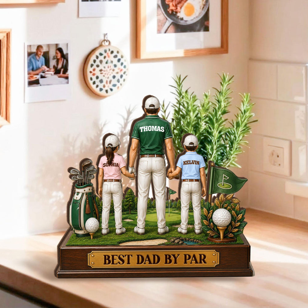 May include: A wooden golf-themed figurine featuring a father and two children holding hands on a miniature golf course. The father wears a green shirt with "Thomas" on the back. The base reads "BEST DAD BY PAR". A golf bag and flag are also present.