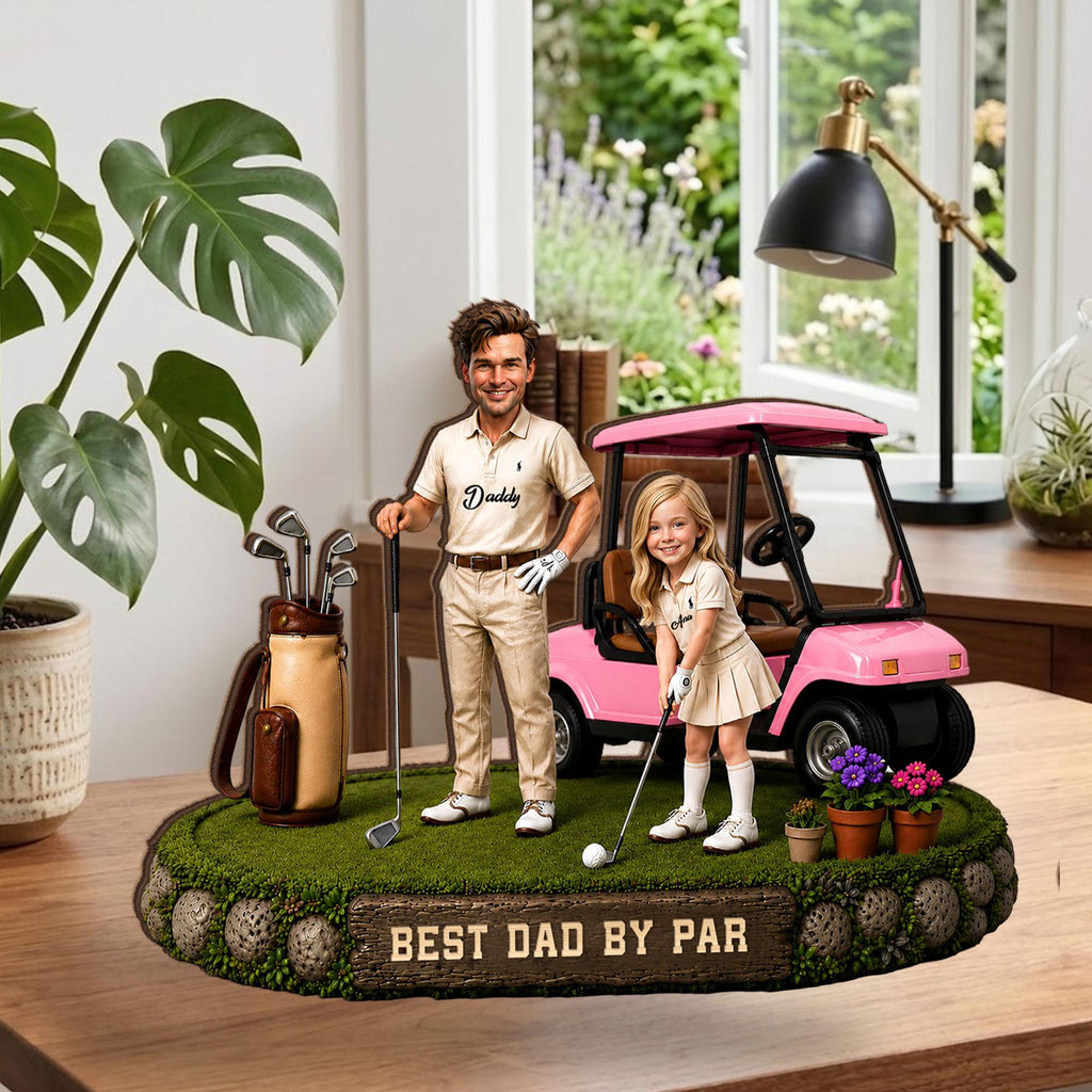 May include: A golf-themed figurine featuring a man and a girl in golf attire, with a pink golf cart. The base is green with the text "BEST DAD BY PAR". A golf bag and clubs are also present.