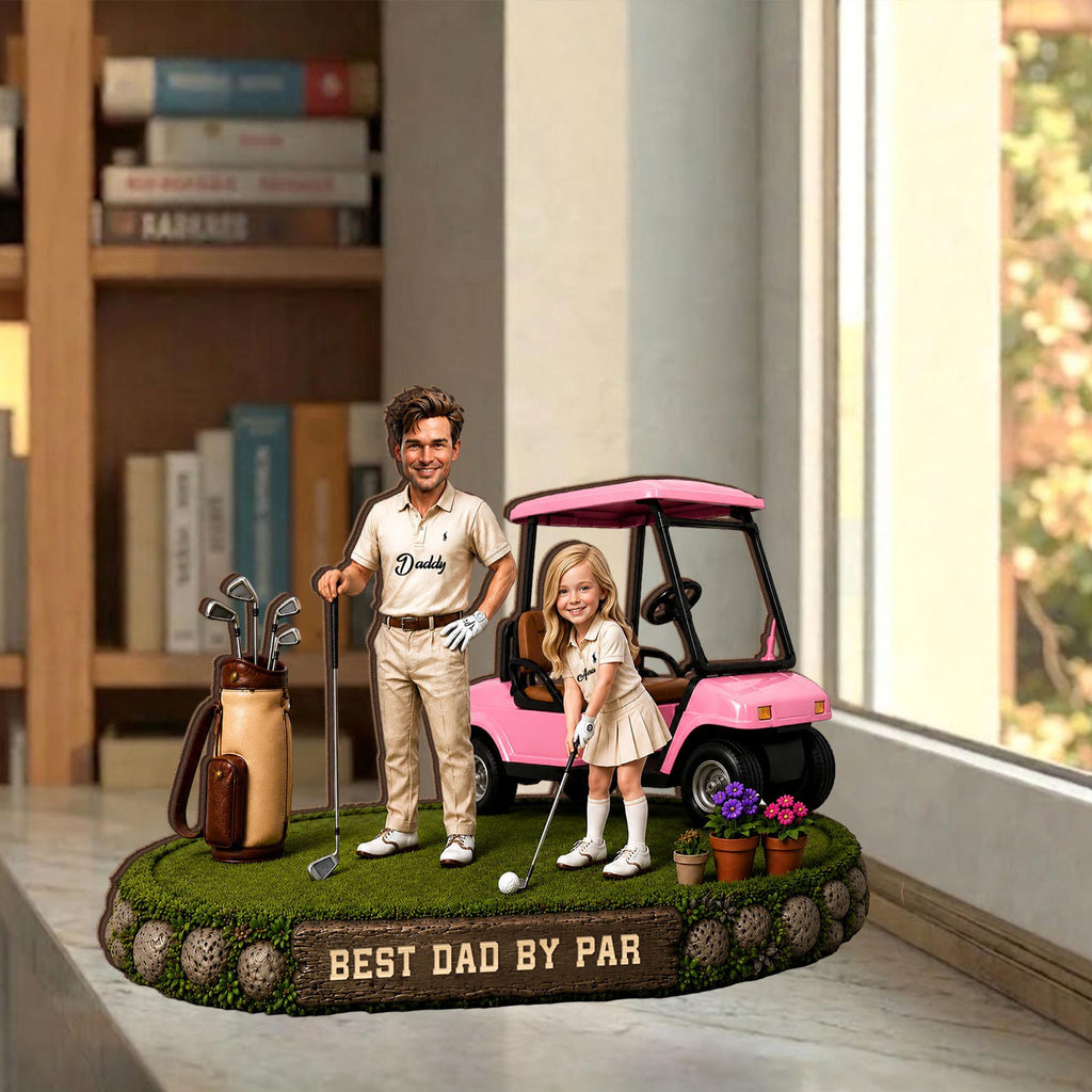 May include: A decorative golf-themed figurine featuring a man and a girl with a pink golf cart. The man wears a polo shirt with "Daddy" on it. The base has the text "BEST DAD BY PAR". A golf bag and potted flowers are also present.