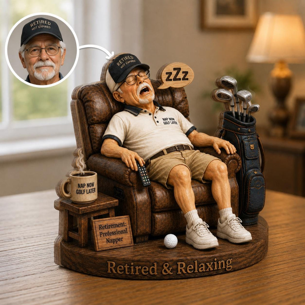 May include: A figurine of a person sleeping in a brown leather recliner, wearing a beige polo shirt with the text 'NAP NOW GOLF LATER' and a black cap reading 'RETIRED NOT EXPIRED'. A golf bag, a mug, and a sign reading 'Retirement: Professional Napper' are included.