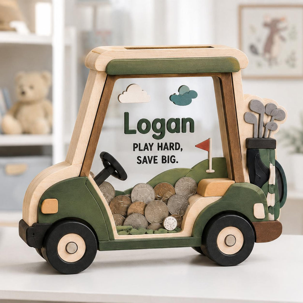 May include: A wooden golf cart shaped piggy bank with a clear front panel containing metal coins. The cart features green and natural wood tones, a black steering wheel, a golf bag with clubs, and the text Logan, PLAY HARD, SAVE BIG.