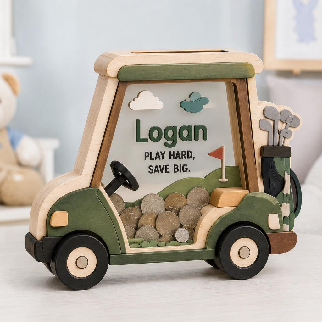 May include: A wooden piggy bank shaped like a golf cart with a clear front panel. It features the name Logan and the text PLAY HARD, SAVE BIG. The design includes green and natural wood tones, a steering wheel, and a golf bag with clubs.