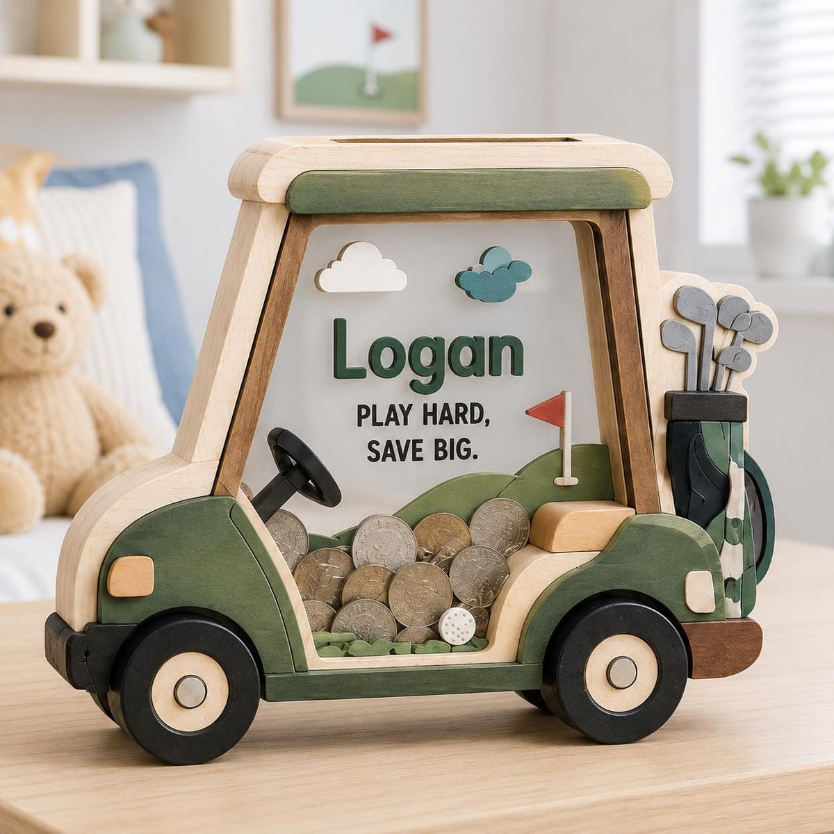 May include: A wooden golf cart-shaped piggy bank with a clear front panel. The text "Logan" and "PLAY HARD, SAVE BIG." is printed on the front. The design includes green and natural wood tones, a steering wheel, and a golf bag with clubs.