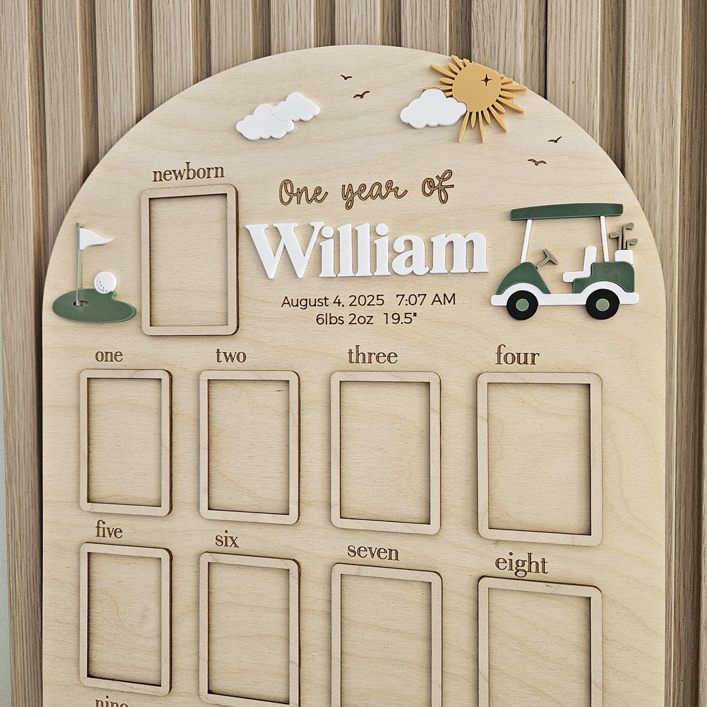 May include: An arched wooden milestone board for William featuring a golf theme with a cart and flag. It includes a photo frame for newborn and months one through twelve, with text displaying August 4, 2025, 7:07 AM, 6lbs 2oz, and 19.5 inches.