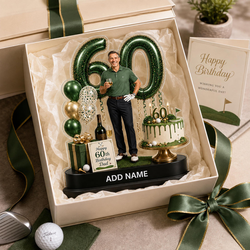 May include: A personalized 60th birthday display set featuring a cutout of a person in a golf shirt, large green number 60 balloons, a miniature cake with a 60 topper, a gift box, and a sign reading Happy 60th Birthday Dad, all in a gift box.