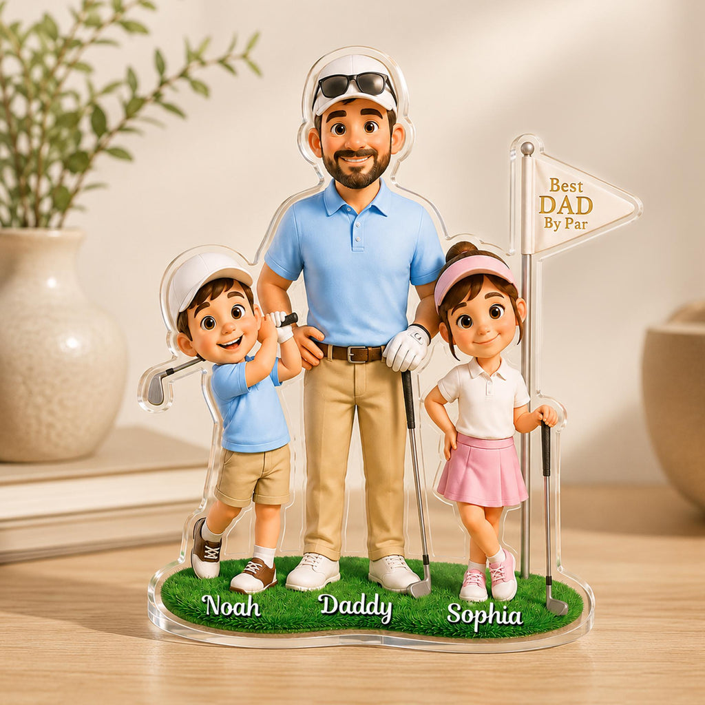 May include: A clear acrylic golf-themed family figurine featuring a father and two children. The father wears a blue polo shirt and khaki pants, while the children are in golf attire. The base is green with the names "Noah", "Daddy", and "Sophia". A flag reads "Best DAD By Par".