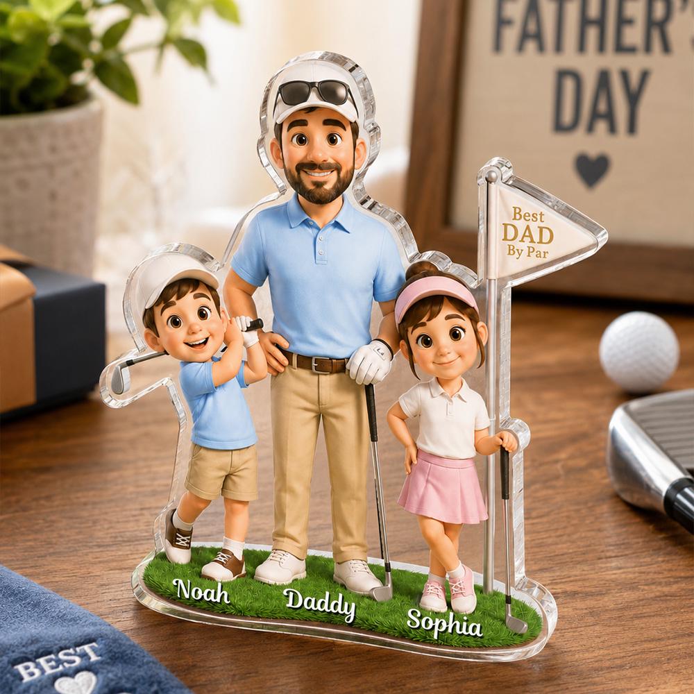 May include: A clear acrylic Father's Day golf-themed figurine. It features a father figure with two children, all dressed in golf attire. The base is green with the names "Noah", "Daddy", and "Sophia". A sign reads "Best Dad By Par".