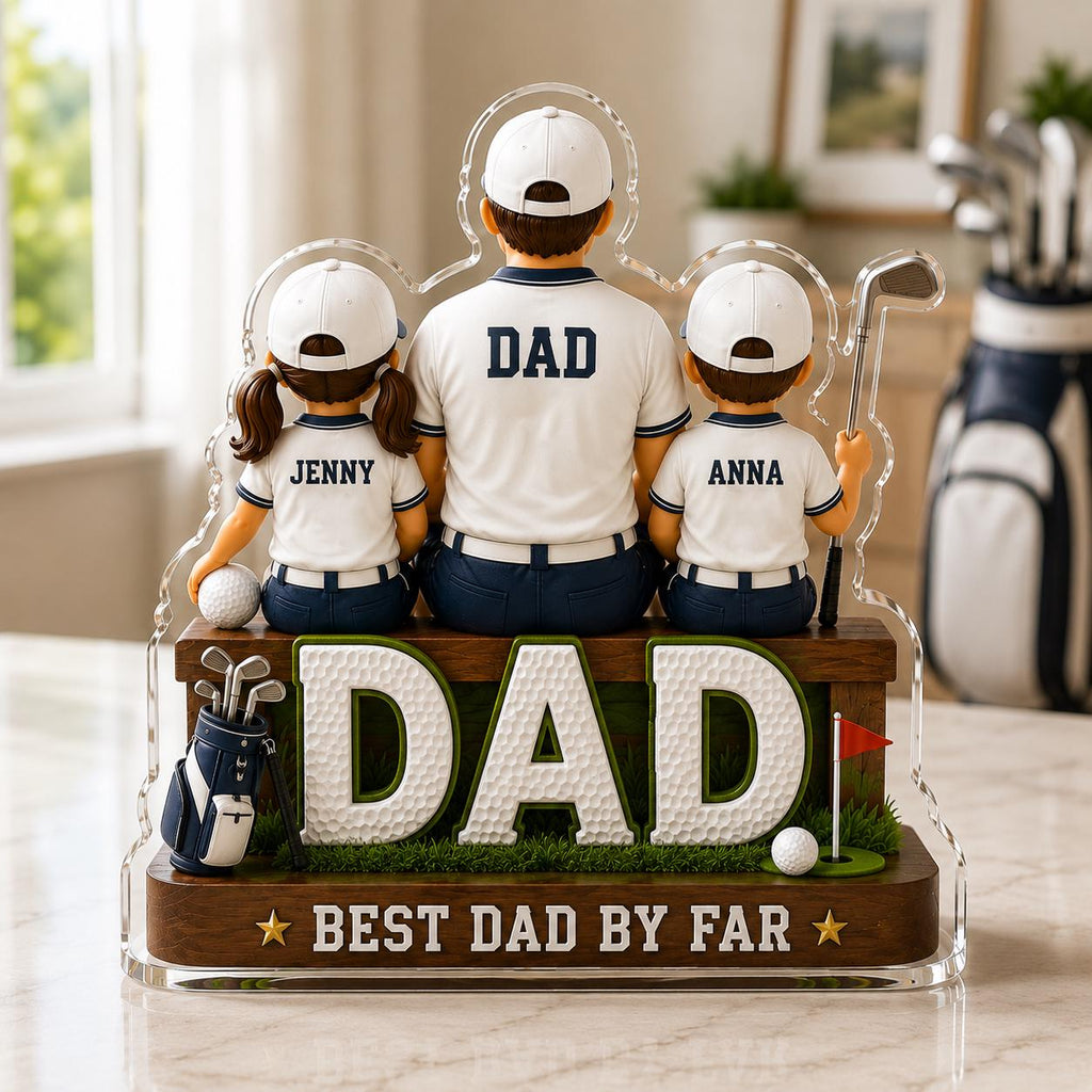May include: A decorative golf-themed figurine featuring a father and two children, all wearing white shirts and caps. The word "DAD" is prominently displayed, along with "BEST DAD BY FAR". A golf bag, golf balls, and a red flag are also included.