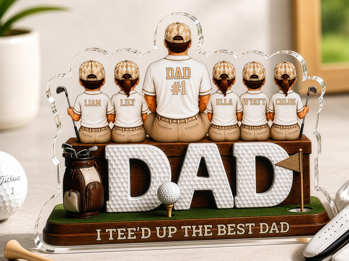 May include: A decorative acrylic display featuring a central figure wearing a shirt labeled DAD #1, flanked by five smaller figures in matching golf attire with names Liam, Lily, Ella, Wyatt, and Chloe. The base reads I TEE'D UP THE BEST DAD.