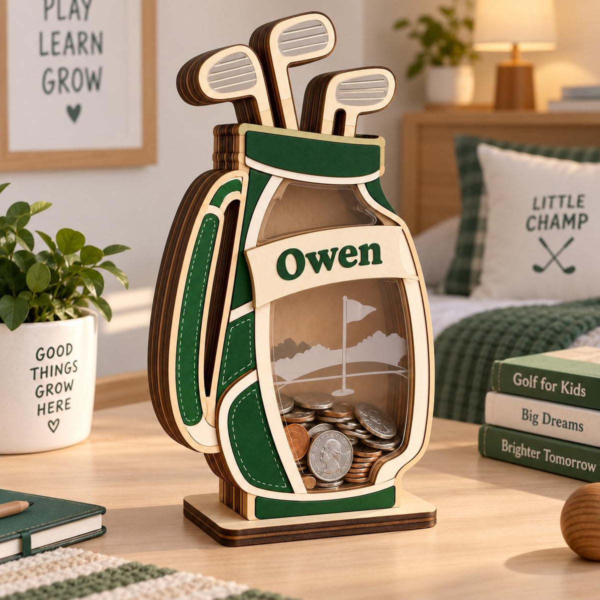 May include: A wooden golf bag-shaped coin bank with a clear front panel, featuring the name Owen printed on a white banner. The bank is painted in dark green and cream, contains various metal coins, and has three golf club cutouts at the top.