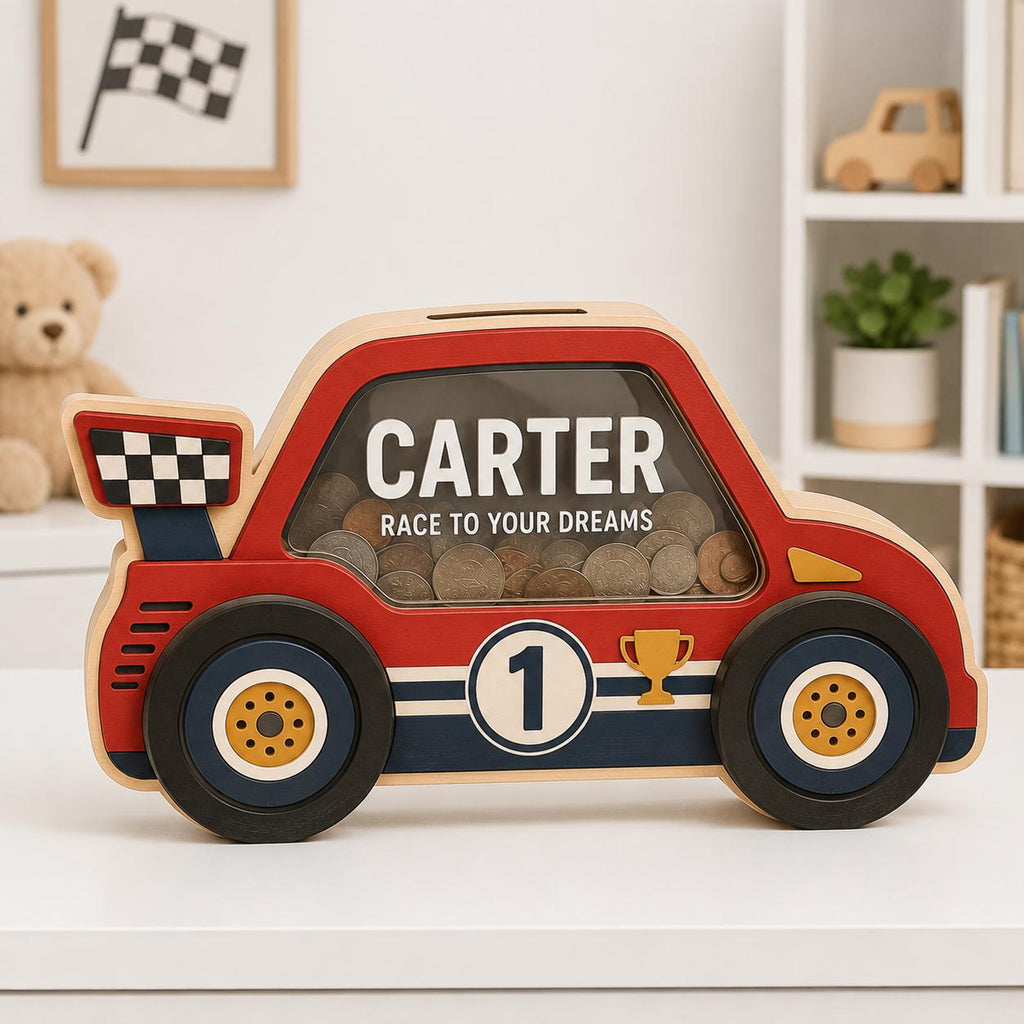 May include: A red, blue, and yellow wooden car-shaped piggy bank with a clear window. The side features the name CARTER, the text RACE TO YOUR DREAMS, a number 1 in a circle, and a trophy icon. A checkered flag spoiler is attached to the back.