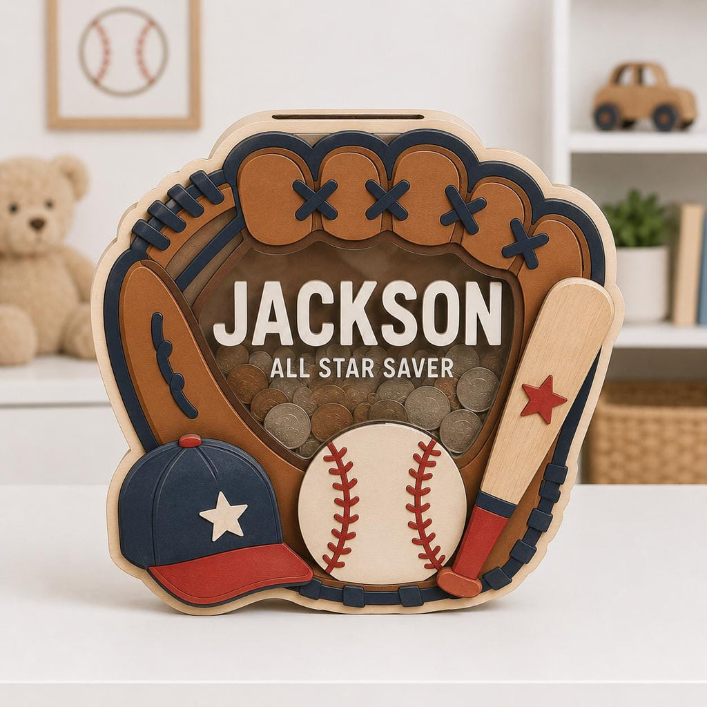 May include: A wooden baseball glove-shaped piggy bank with a clear front panel containing coins. It features the name JACKSON and the text ALL STAR SAVER. The design includes a blue and red baseball cap, a baseball, and a wooden bat with a red star.