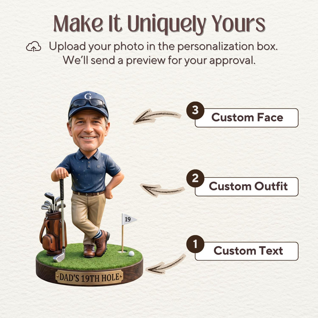 May include: A custom bobblehead figurine of a golfer wearing a navy polo shirt, khaki pants, and a navy cap, standing on a green base with a golf bag and a flag labeled 19. The base features a plaque with the text DAD'S 19TH HOLE and numbered labels.
