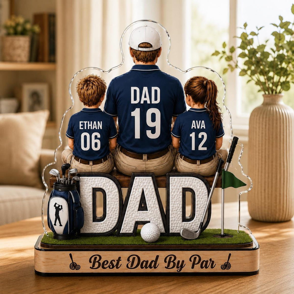 May include: A personalized golf-themed acrylic display featuring the word "DAD" in large letters, a golf ball, and a golf club. The display shows a father and two children with their names and numbers on their shirts. The base reads "Best Dad By Par."