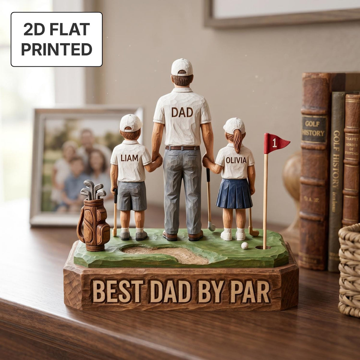 May include: A golf-themed figurine featuring a father and two children, holding hands. The father's shirt reads "DAD", and the base says "BEST DAD BY PAR". The children's shirts are labeled "LIAM" and "OLIVIA". A golf bag and flag are also present.