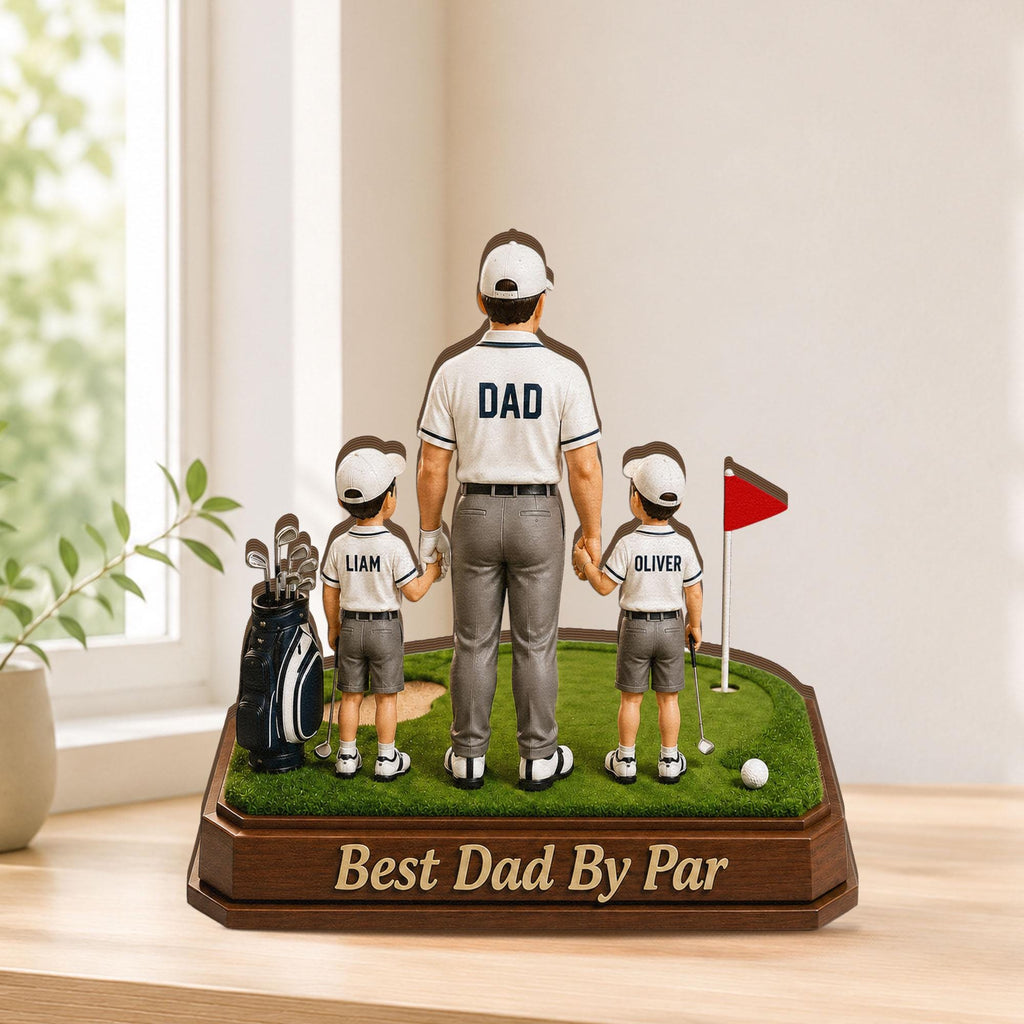 May include: A golf-themed figurine featuring a father and two sons on a miniature green. The father wears a shirt with "DAD" on the back. The base reads "Best Dad By Par". A golf bag, flag, and ball are also present.