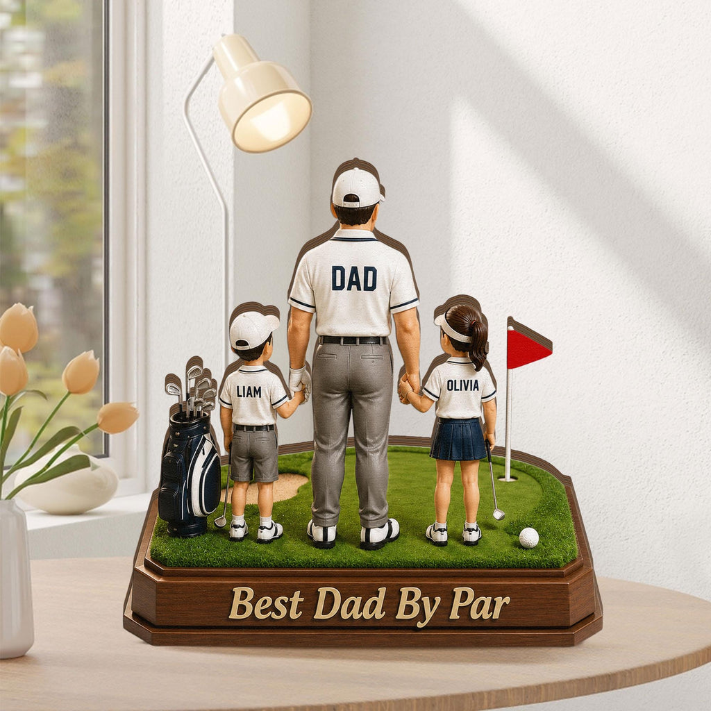 May include: A golf-themed figurine featuring a father and two children on a miniature green. The father's shirt reads "DAD", and the base says "Best Dad By Par". The children's shirts have names. A golf bag and flag are also present.