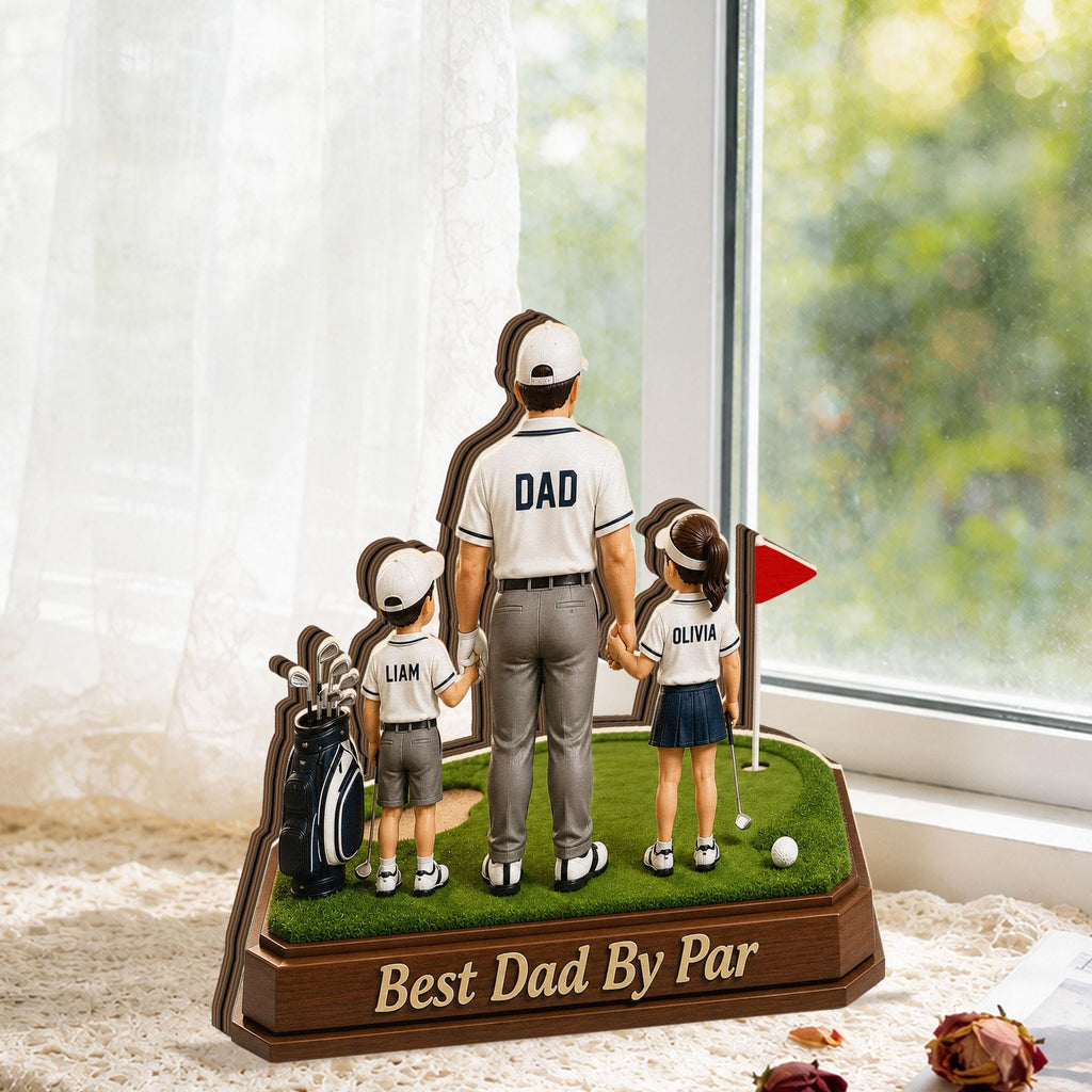 May include: A decorative golf-themed figurine featuring a father figure with two children, a boy and a girl, on a miniature golf course. The father figure has the word "DAD" on his shirt. The base reads "Best Dad By Par."