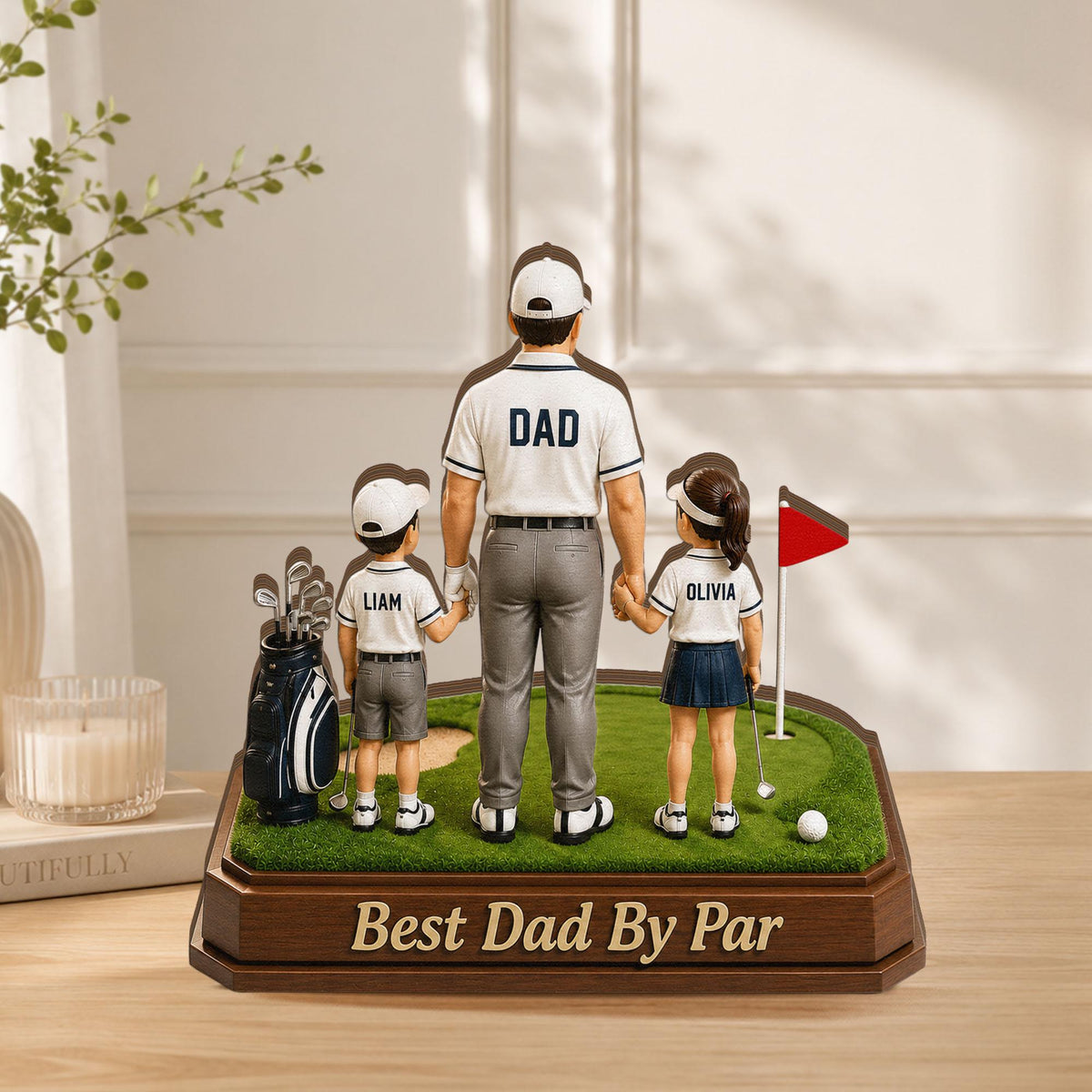 May include: A decorative golf-themed figurine featuring a father figure with two children, holding hands on a miniature golf course. The father's shirt reads "DAD". The base reads "Best Dad By Par". A golf bag and flag are also present.