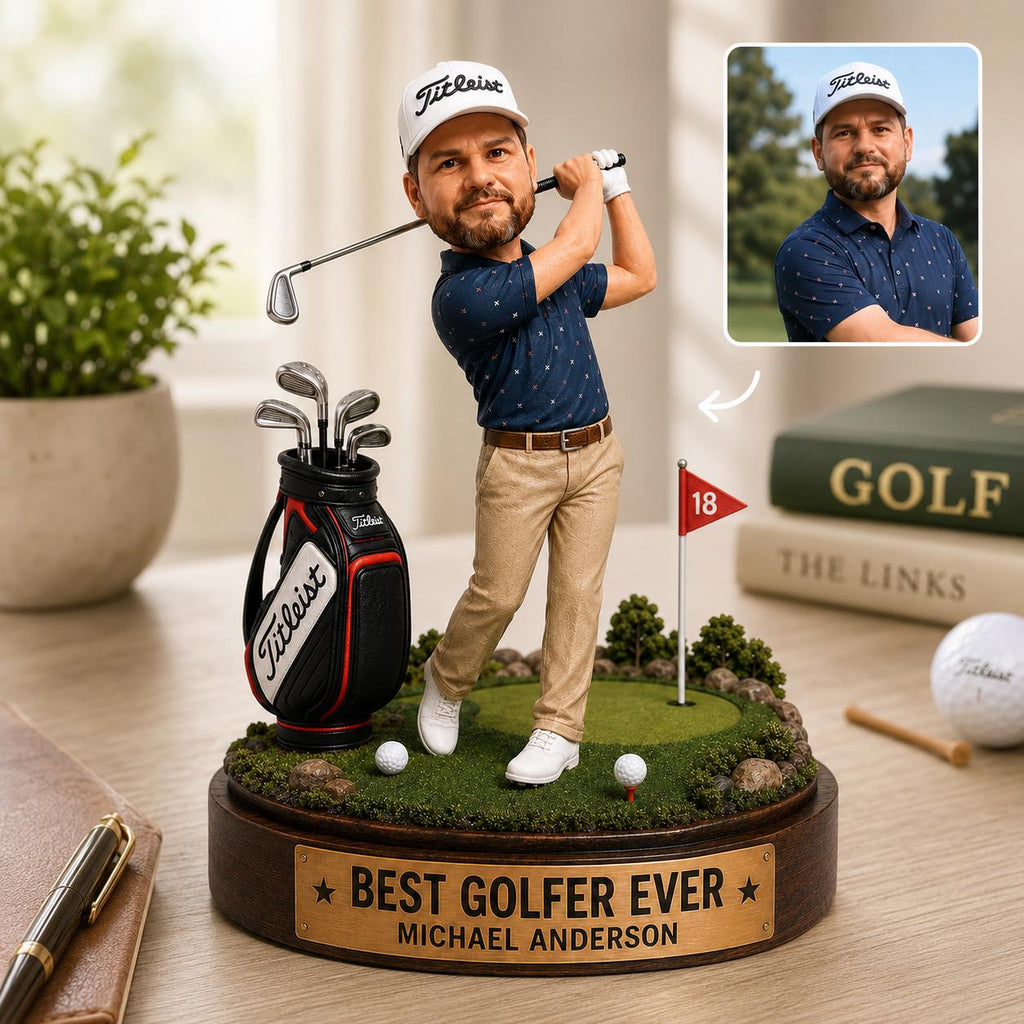 May include: A custom bobblehead figurine of a golfer wearing a white Titleist cap, navy patterned polo, and tan trousers, swinging a club. The base features a green putting area, a golf bag, a red flag with 18, and a plaque reading BEST GOLFER EVER.