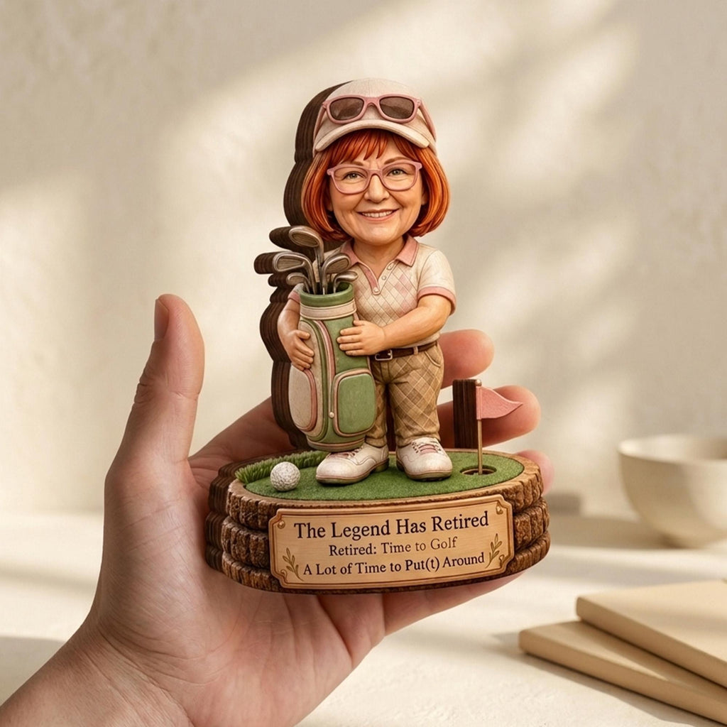 May include: A figurine of a golfer with reddish hair, glasses, and a cap, holding a golf bag. The base features a golf hole, a ball, a flag, and a plaque reading: The Legend Has Retired, Retired: Time to Golf, A Lot of Time to Put(t) Around.