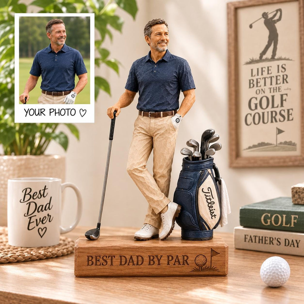 May include: A custom figurine of a golfer wearing a navy blue polo shirt and khaki pants, standing on a wooden base engraved with "BEST DAD BY PAR". The figure holds a golf club next to a blue golf bag with "Titleist" text and a white golf ball.