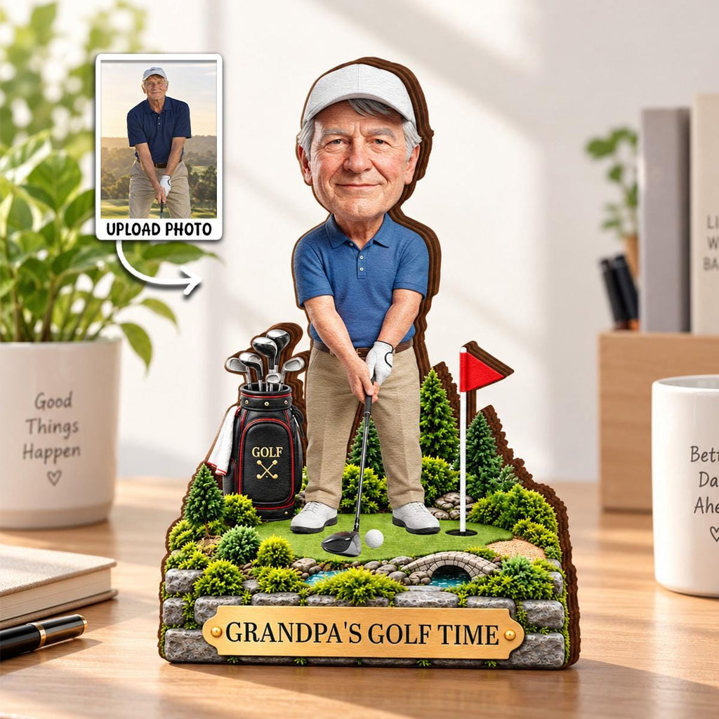 May include: A custom bobblehead figure of a golfer wearing a blue polo shirt and khaki pants, standing on a miniature golf course base with a golf bag, flag, and stone bridge. A plaque at the front reads "GRANDPA'S GOLF TIME" in gold lettering.