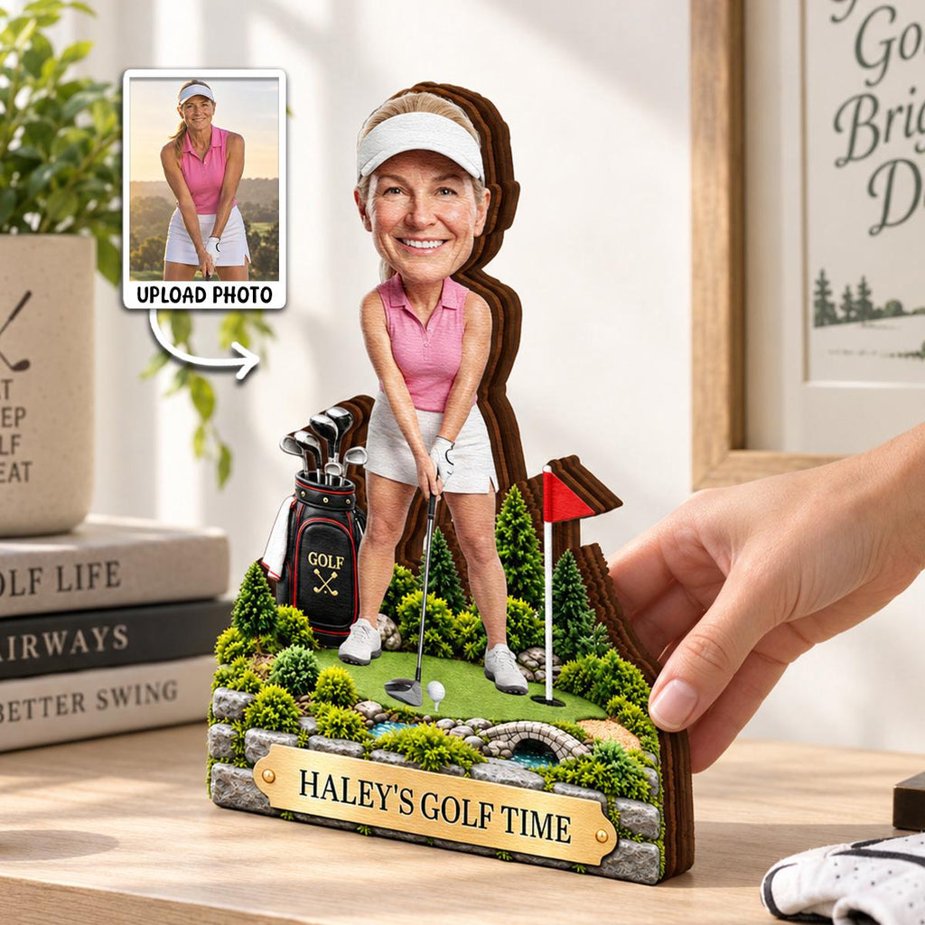 May include: A custom wooden golf-themed figurine featuring a person in a pink polo shirt and white visor standing on a green course with a golf bag, a red flag, and a stone bridge. A gold plaque at the base displays the text HALEY'S GOLF TIME.
