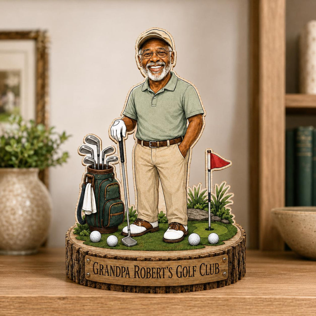 May include: A wooden tabletop display featuring a cartoon illustration of an older golfer in a green polo shirt and khaki pants. The figure stands on a green base with a golf bag, clubs, balls, and a flag. A plaque reads: GRANDPA ROBERT'S GOLF CLUB.