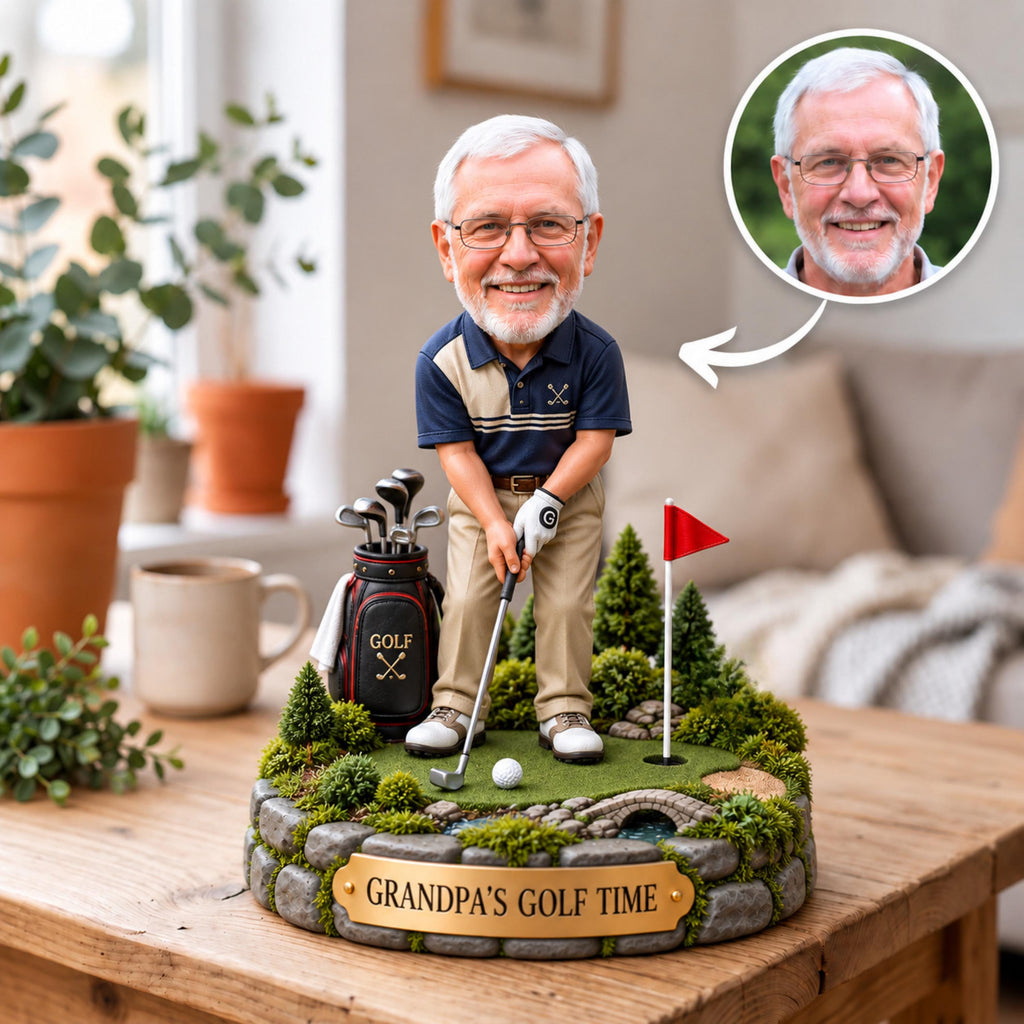 May include: A custom bobblehead figurine of an older man with glasses wearing a navy and tan polo shirt, khaki pants, and a golf glove. The figure stands on a miniature golf course base with a golf bag, a red flag, and a plaque reading GRANDPA'S GOLF TIME.
