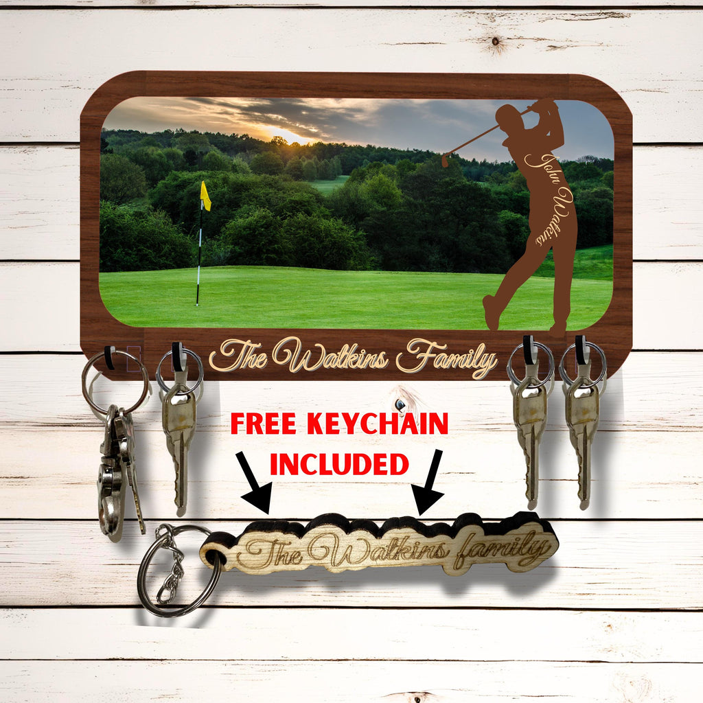 May include: A wooden key holder with a golf-themed design. It features a scenic golf course image and a silhouette of a golfer. The key holder includes a free keychain and the text "The Watkins Family".