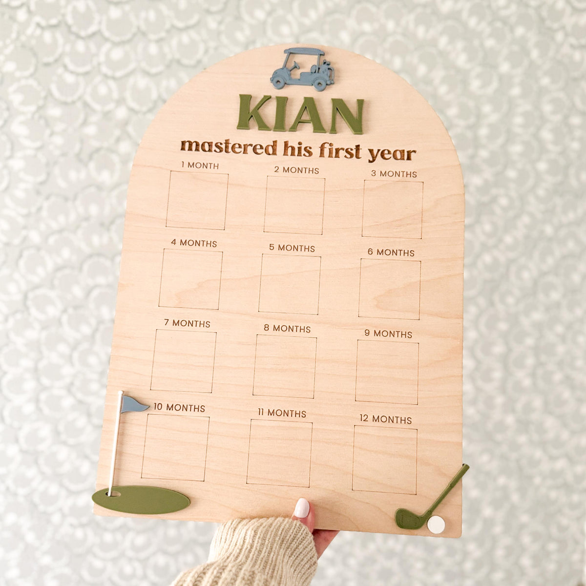 Hand holding personalized golf milestone board, demonstrating scale and design details of wood and acrylic sign