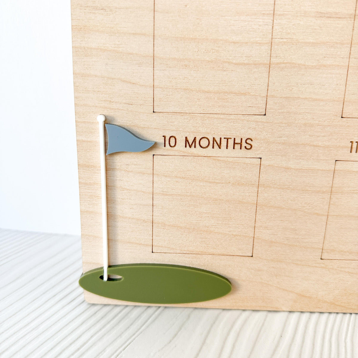 close up detail of wood grain and acrylic golf elements on birthday milestone board , showing close up high-quality craftsmanship and detailed engraving