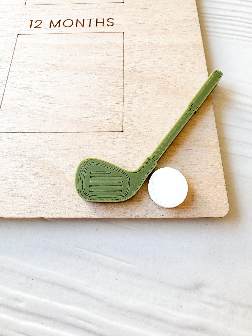 Detail of wood grain and acrylic golf ball and stick on golf birthday milestone board , showing close up high-quality craftsmanship and detailed engraving